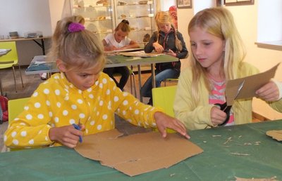 Juno, Maxima, Klara und Annika (von links) müssen entscheiden, welche Flachfigur sie aus der Pappe schneiden wollen.