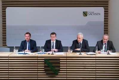 Jens Jungmann (v.l.), Pressesprecher des Sächsischen Wirtschaftsministeriums, der Wirtschaftsminister und stellvertretende Ministerpräsident von Sachsen, Martin Dulig (SPD), Sachsens Ministerpräsident Stanislaw Tillich (CDU) und der Regierungssprecher Christian Hoose in der Sächsischen Staatskanzlei in Dresden während einer Pressekonferenz.