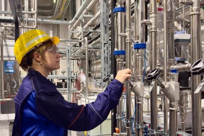 Doktorandin Viktoriia Kison prüft den Kühlkreis für den Plasmabrenner.