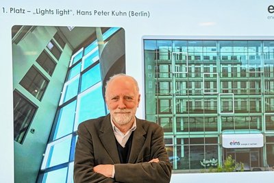 Hans Peter Kuhn vor einer Animation seiner Installation. Ein Zufallsgenerator entscheidet, welche und wie viele Rechtecke in der Glasfassade des Eins-Firmensitzes beleuchtet werden. Das Ganze erinnert an Schachspielen oder alte Computerspiele. Strom verbraucht das Kunstwerk kaum.