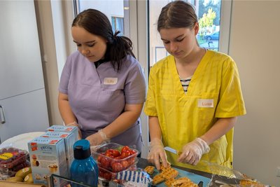 Lilly Richter (l.) und Luisa Jaeger (r.) von der Berufsschule für Pflegeberufe bereiten Fingerfood in der Tagespflege Brand-Erbisdorf zu.