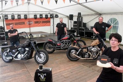 Volker Lorenz, Christian Rödel und Jens Rödel (von links) präsentieren einen Teil der zu sogenannten Costumbikes umgebauten Maschinen, die zum Treffen an diesem Wochenende in Coschütz mit dabei sind. Recht im Bild: Gerhild Lorenz mit dem Pokal, über dessen Vergabe das Publikum entscheiden wird. 