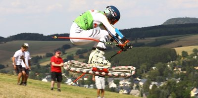Lukas Richter vom Grasskiteam Erzgebirge während des Sprungs beim Super-G. Wenig später musste auch Vater Torsten Richter (r.) mit ansehen, wie eine Rolle brach und sein Sohn stürzte. 