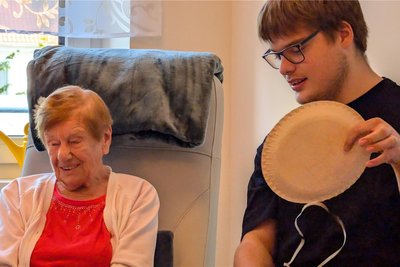 Erik Schiller (r.) erklärt das Punktespiel in der Tagespflege Brand-Erbisdorf.