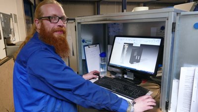 Mithilfe seines Computers programmiert Christian Brückner eine Stanz- und Abtrennpresse. 