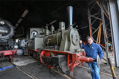 Das neue Zuhause für die Dampflok „Hegel" ist der imposante Lokschuppen in Hilbersdorf. Hier steht sie Seite an Seite mit anderen historischen Lokomotiven. Im Bild: Museumsleiter Maximilian Claudius Noack.