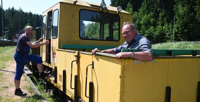 Danny Jokisch, der stellvertretende Vorsitzende des Fördervereins Historische Westsächsische Eisenbahnen (l.) und Vereinsmitglied Frank Dehnel an einer der Draisinen, die den Wernesgrüner Schienenexpress ziehen, wenn er nach Hammerbrücke fährt. 