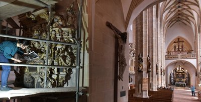 Das hölzerne Denkmal befindet sich im Eingangsbereich des Domes an der Westseite des Turmpfeilers und nimmt dort fast die gesamte Höhe der Turmhalle ein. Samah Shtay aus Syrien, Studentin im achten Semester, vergleicht Details mit einem Ausdruck aus dem Archiv.
