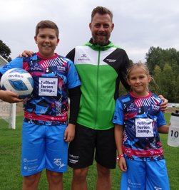 Henry und Nancy Baumgärtel aus Marieney - beide spielen für den VFC Adorf - im extra angefertigten Jubiläums-Outfit zusammen mit Camp-Chef Matthias Krauß.