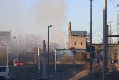 Dichter Rauch steigt am Rande der Bahnanlagen nahe der Straße der Nationen auf.