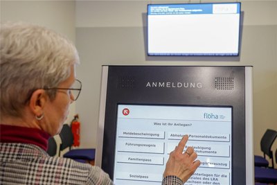 IT-Beauftragte Birgit Pestel zeigt am Wartebereich-Terminal die Anmeldung ohne vorab vereinbarten Termin. Thema auswählen, drücken ...