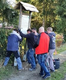 Die Infotafel zum Steigerhaus wird an ihren neuen Standort versetzt.