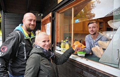 Annegret Damerau und Matthias Käsler zählten zu den ersten Gästen am wiedereröffneten Imbiss auf der Hohen Reuth in Schöneck. Lucas Sattler wird im Auftrag des neuen Betreibers dort arbeiten. 