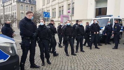Die Polizei ist mit einem Großaufgebot vor Ort. Auch Vertreter der rechtsextremistischen Partei Dritter Weg sowie der sogenannten Querdenker-Bewegung sind gekommen.