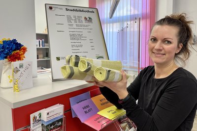 Juliane Bochmann vom Team der Stadtbibliothek Schwarzenberg zeigt, dass es die gelben Säcke künftig hier gibt.