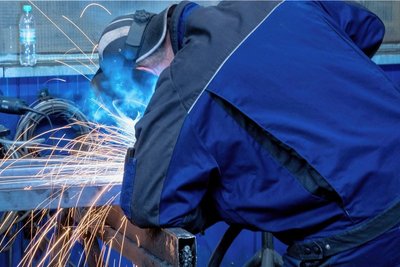 Ein Schweißer arbeitet in der Werkhalle eines Metallbauunternehmens. Hohe Energiekosten belasten auch diese Branche - kann ein Unternehmen seine Beschäftigten daher in Kurzarbeit schicken? 