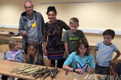 Nils Kochan und Eva Bredow vom Hollerhof in Reichenau (v. l. stehend) gestalten unter anderem ebenfalls Projekte für Ferienkinder. Am Dienstag gab es in der Grundschule Frauenstein einen Workshop zum Instrumente basteln.