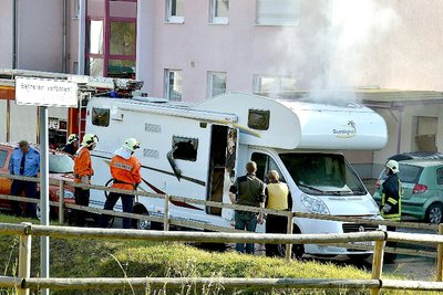 ARCHIV - Feuerwehrleute und Polizisten stehen am 04.11.2011 in Eisenach vor einem qualmenden Wohnwagen, in dem zwei Leichen entdeckt wurden. Die Polizeimaßnahmen unmittelbar nach dem Auffliegen der rechten Terrorzelle «Nationalsozialistischer Untergrund» (NSU) am 4. November 2011 in Eisenach werfen neue Fragen auf.