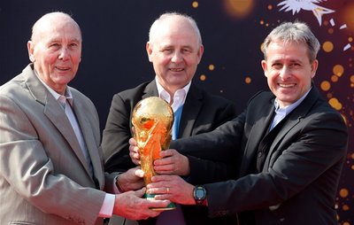 Die ehemaligen Fußball-Nationalspieler und Weltmeister Horst Eckel, Bernd Hölzenbein und Pierre Littbarski mit der originalen Fifa WM-Trophäe.