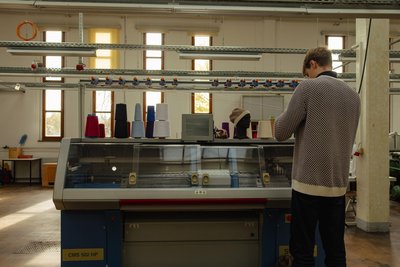 Die „Stoll“ ist eine Flachstrickmaschine. Jan Gerstner baut eine Handyhalterung, um ihre Arbeit besser filmen zu können.