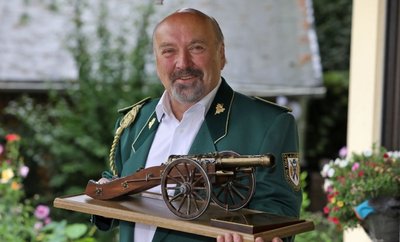 Hermann Scherzer zeigt den Wanderpokal in der Form einer Schützen-kanone.