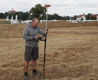 Frank Amling von der beauftragten Vermessungsfirma bei seiner Arbeit auf dem Grundstück.