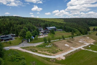 Baustopp: Unmittelbar unterhalb der Emil-Riedel-Straße liegt die Fläche, auf der die Ferienhäuser entstehen sollen. Oberhalb der Straße steht das Hotel von Jens Weißflog.