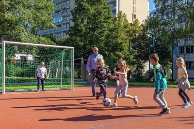 Oberbürgermeister Jens Scharff  war auf dem neuen Kunststoffbelag zusammen mit Schülerinnen der Klasse 3a am Ball. 