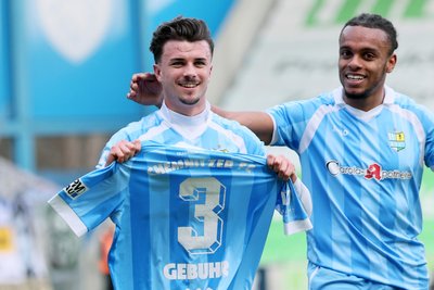 Leon Damer – hier mit Martial Ekui – hält das Trikot von Dario Gebuhr in die Kamera, der sich im Abschlusstraining verletzte.