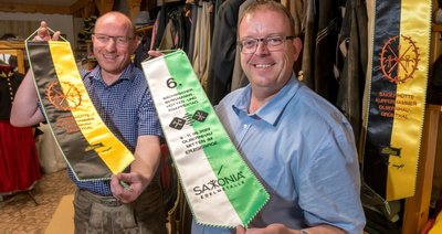 Udo Brückner (l.), Leiter des Regiebetriebes Kultur und Tourismus der Stadt Olbernhau, hat am Freitag beim Marienberger Maßschneidermeister Markus Seiler 105 Fahnenschleifen abgeholt. 