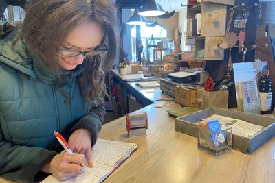 Aufträge und Termine werden noch ganz klassisch im Auftragsbuch notiert – Jessica Neudel bei der Arbeit.