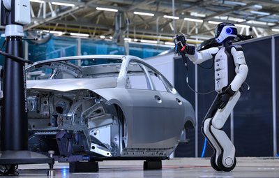 Ein humanoider Roboter prüft im BMW-Werk Leipzig eine Fahrzeugkarosserie auf mögliche Abweichungen und Fehler.