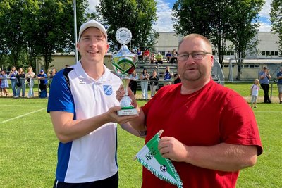Staffelleiter Nico Lässig (rechts) überreicht Mosels Kapitän Sebastian Springer (links) die Meistertrophäe.