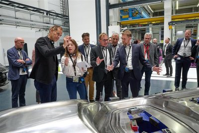 Zwischenstopp an einem Karosserieteil: Die Delegation um Porsche-Vorstandschef Oliver Blume (2. v. l.) hat einen Rundgang durch die Werkhallen in Schwarzenberg gemacht. Mit dabei: Ministerpräsident Michael Kretschmer (M.), hier im Gespräch mit Geschäftsführer Markus Kreutel.