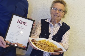 91-Jährige erfindet neues Harzer Gericht "Wilder Stinker" - Die 91-jährige Herzbergerin Käthe Neukirch präsentiert am 15.09.2017 in Herzberg (Niedersachsen) das neue Harzer Regionalgericht "Wilder Stinker". Dabei handelt es sich um eine durch heimische Kräuter verfeinerte Wildschwein-Bratwurst. Sie wird mit Harzer Käse überbacken und dann an einer mit Harzer Beerenlikör verfeinerten Currysauce serviert