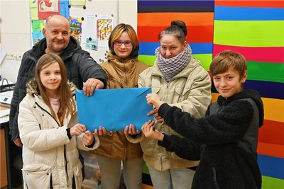 Jens, Mia und Melanie Hammer (hinten, v. l.) nehmen von den Klassensprechern Layla (l.) und Fynn (r.) den Erlös des Kuchenbasars entgegen. 