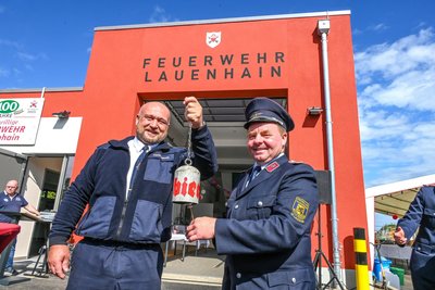 Geschenk von René Golsch (l.) von der Feuerwehr Burgstädt: Eine Glocke, hergestellt aus einer Druckluftflasche. Wehrleiter Henry Schöne aus Lauenhain freut sich.