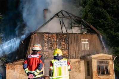 Die Einsatzkräfte versuchen, in das ausgebrannte Haus zu gelangen.