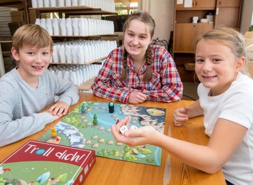 Zwei Würfel und los geht's: Raphaela Haude (Mitte) sowie Felix und Laura Franke probierten das erste fertiggestellte Spiel gleich in der Seiffener Werkstatt von Tino Günther aus.
