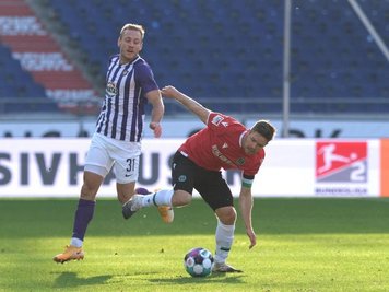            Hannovers Dominik Kaiser (r) und Ben Zolinski von Erzgebirge Aue kämpfen um den Ball.