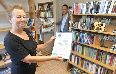 Bibliothekarin Karin Lohse (vorn) freut sich über den Fördermittelbescheid zur Modernisierung der Einrichtung. Überbracht wurde er von CDU-Bundestagsabgeordneter Veronika Bellmann und Bürgermeister René Straßberger.
