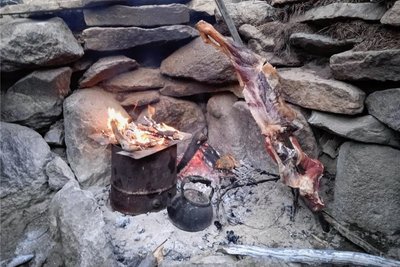 Das typische Assado: Ziege am Spieß. Dazu ein Wasserkessel für Mate und links der Backofen für Brot aus Weizenmehl.