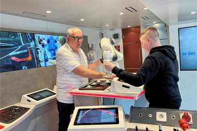 Einen Cobot (Industrieroboter) testet der Achtklässler Yannik Dürr gemeinsam mit dem Berater Andreas Ottenberg im Inneren des Informationstrucks. 