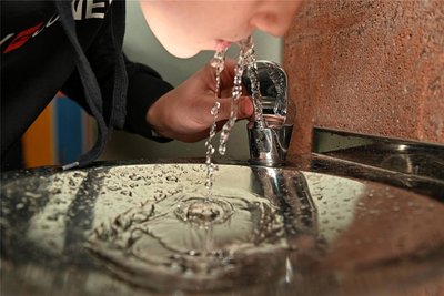 Ein Schüler genießt das Trinkwasser.