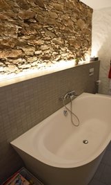 Die originale Gneiswand von 1250 ist bei der Sanierung aufgearbeitet und wie im unteren Treppenhaus beleuchtet worden.