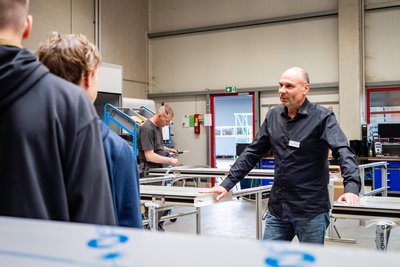 Start der Woche der offenen Unternehmen bei Baierl Demmelhuber Innenausbau GmbH im Gewerbegebiet in Schlegel: Enrico Koch, Leiter der Glas- und Metall-Manufaktur, führte Jugendliche und ihre Eltern durch den Werkstattbereich.