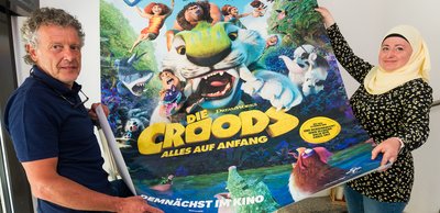 Andreas Helmert und Betty Mietke, die beiden Marienberger Kinobetreiber, zeigen ein Banner für einen Animationsfilm, der ab dem 8. Juli in ihrer Einrichtung gezeigt wird.