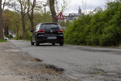 Aufgrund der Sperrungen kürzen Ortskundige über die Hüttengrundstraße ab, um in die Innenstadt zu kommen. Der zusätzliche Verkehr verschlechtert den ohnehin schon desaströsen Zustand.