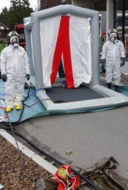 Im Dekontaminationszelt wird mit Wasser grob gereinigt.