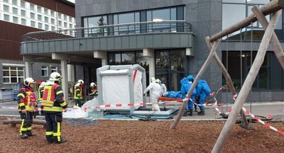 Ein Verletzter wird aus dem Gefahrenbereich zur Dekontaminationsstrecke transportiert. 